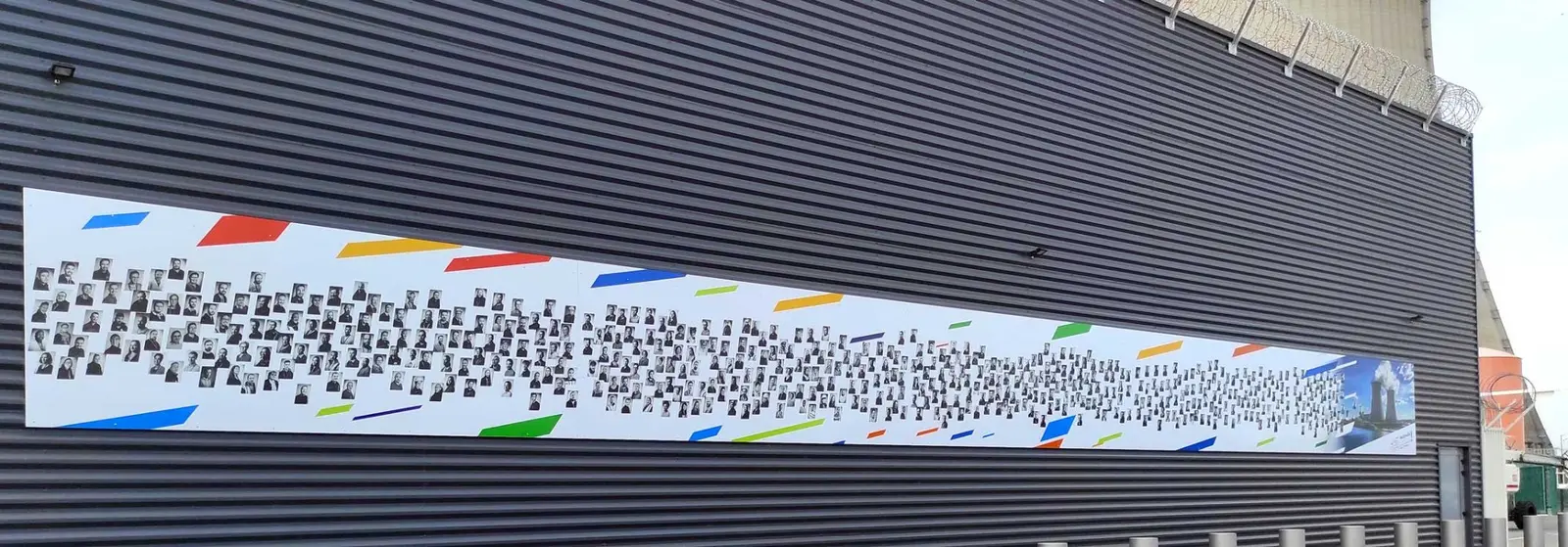 Fresque monumentale de 850 portraits installée sur la façade d'un bâtiment industriel