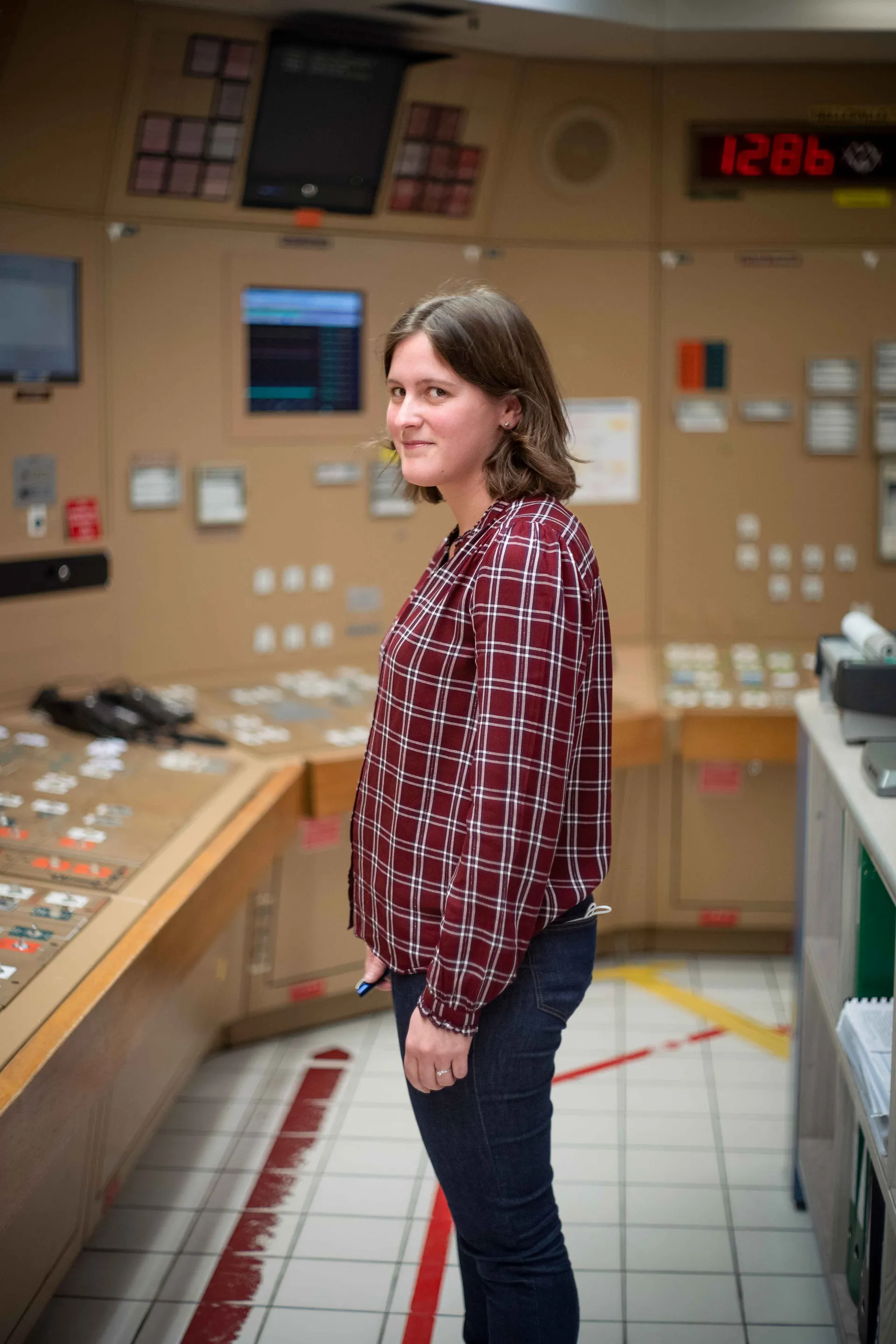 Ouvrière éclatant de rire à son poste de travail, tablier blanc et lunettes, atelier de la Faïencerie de Gien