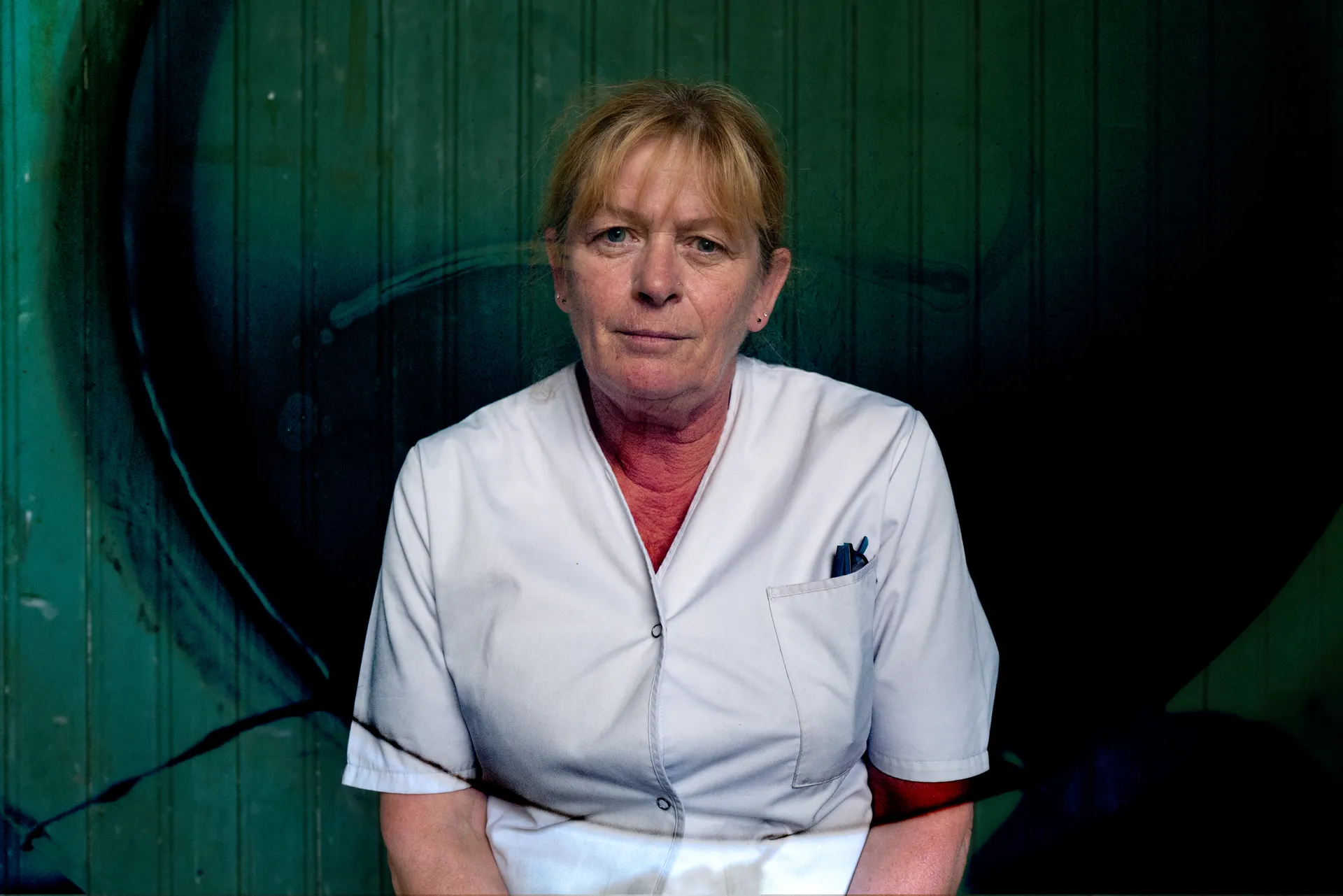 Technicien Alkia en gilet haute visibilité orange, badges et clés, devant les tours de refroidissement d'une centrale nucléaire