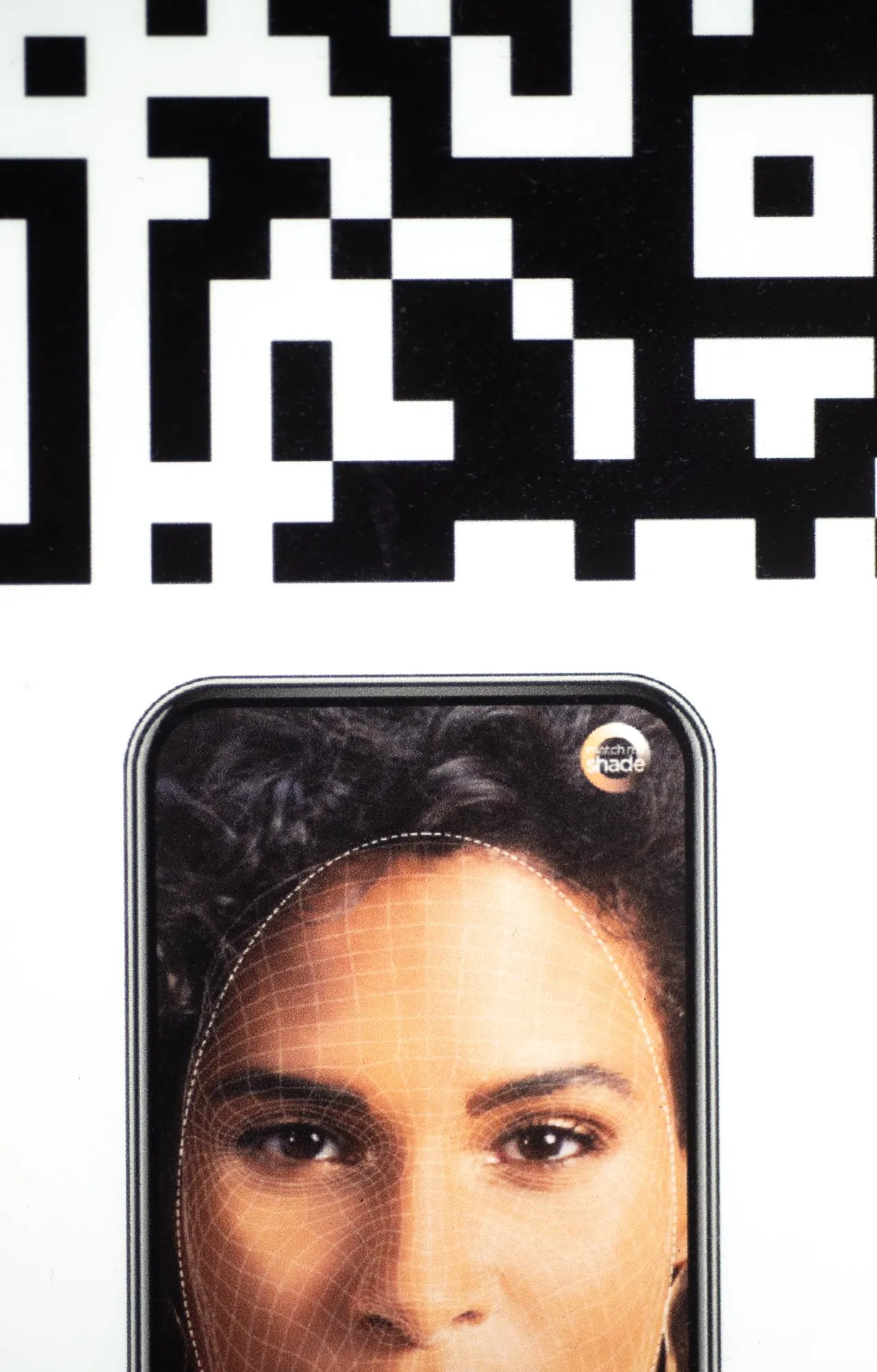 QR code g&eacute;ant et visage sur &eacute;cran avec grille de reconnaissance faciale