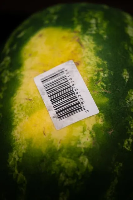 Gros plan past&egrave;que avec &eacute;tiquette code-barres coll&eacute;e sur la peau du fruit