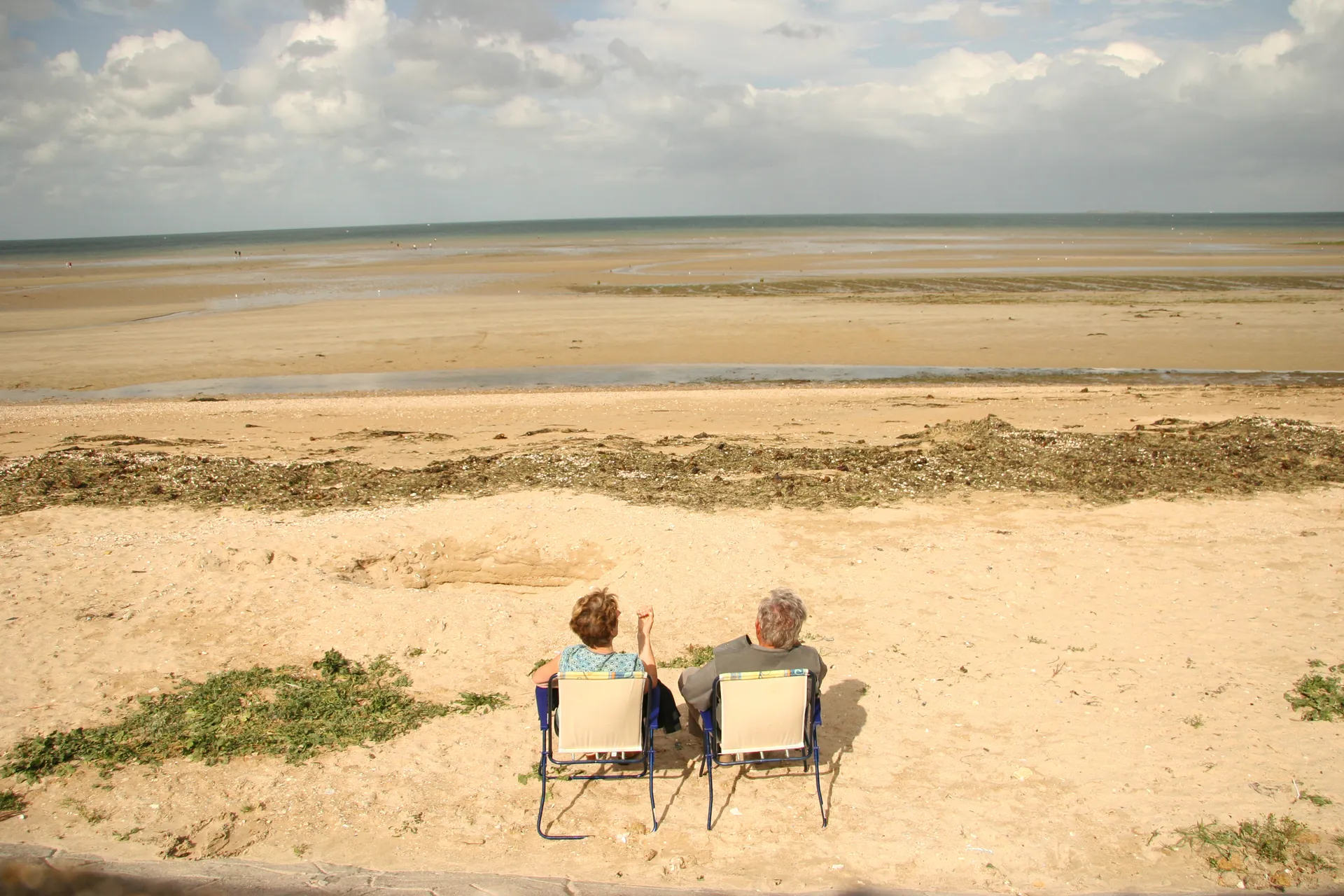 Silhouette seule au bout d'une jetée, mer calme, ciel gris argenté