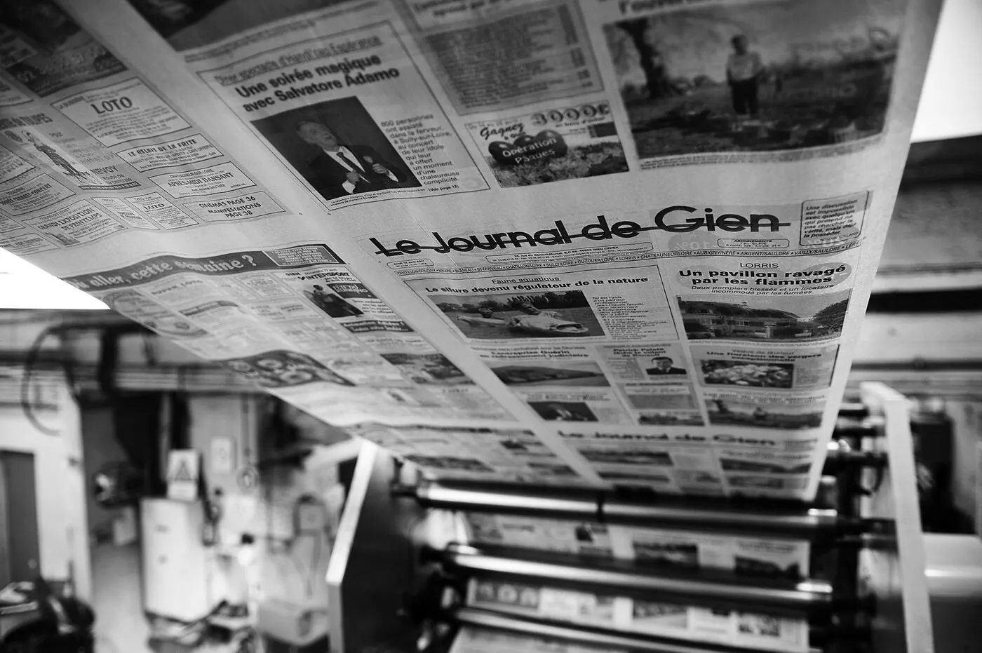Archiviste consultant un ancien numéro dans la salle d'archives du Journal de Gien