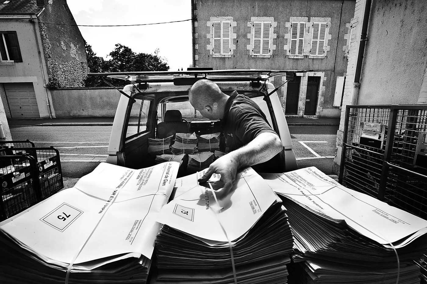 Rouleaux de la rotative pliant le papier journal, détail mécanique en clair-obscur