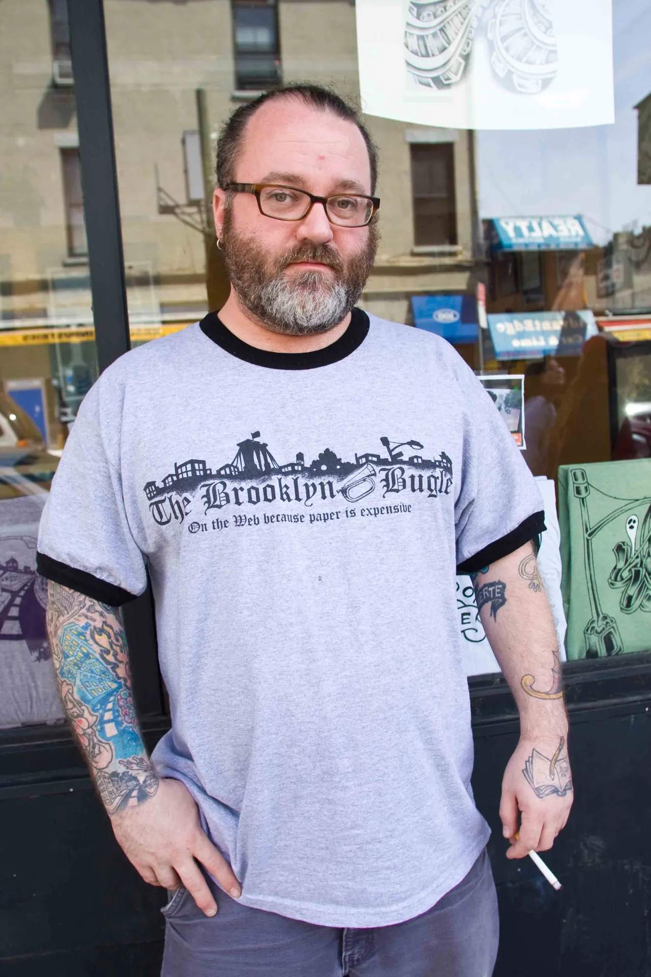 Portrait d'un New-Yorkais en t-shirt imprimé devant un mur de briques