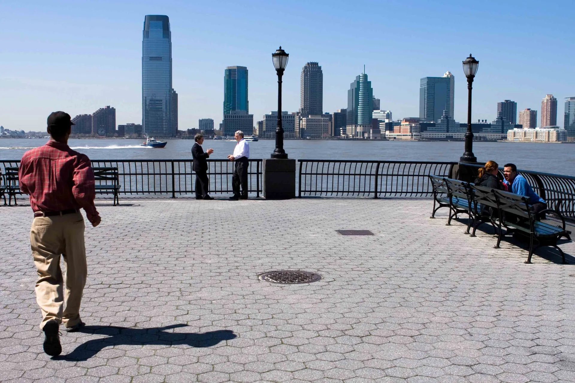 Cycliste sur une esplanade avec le skyline de Manhattan en arrière-plan