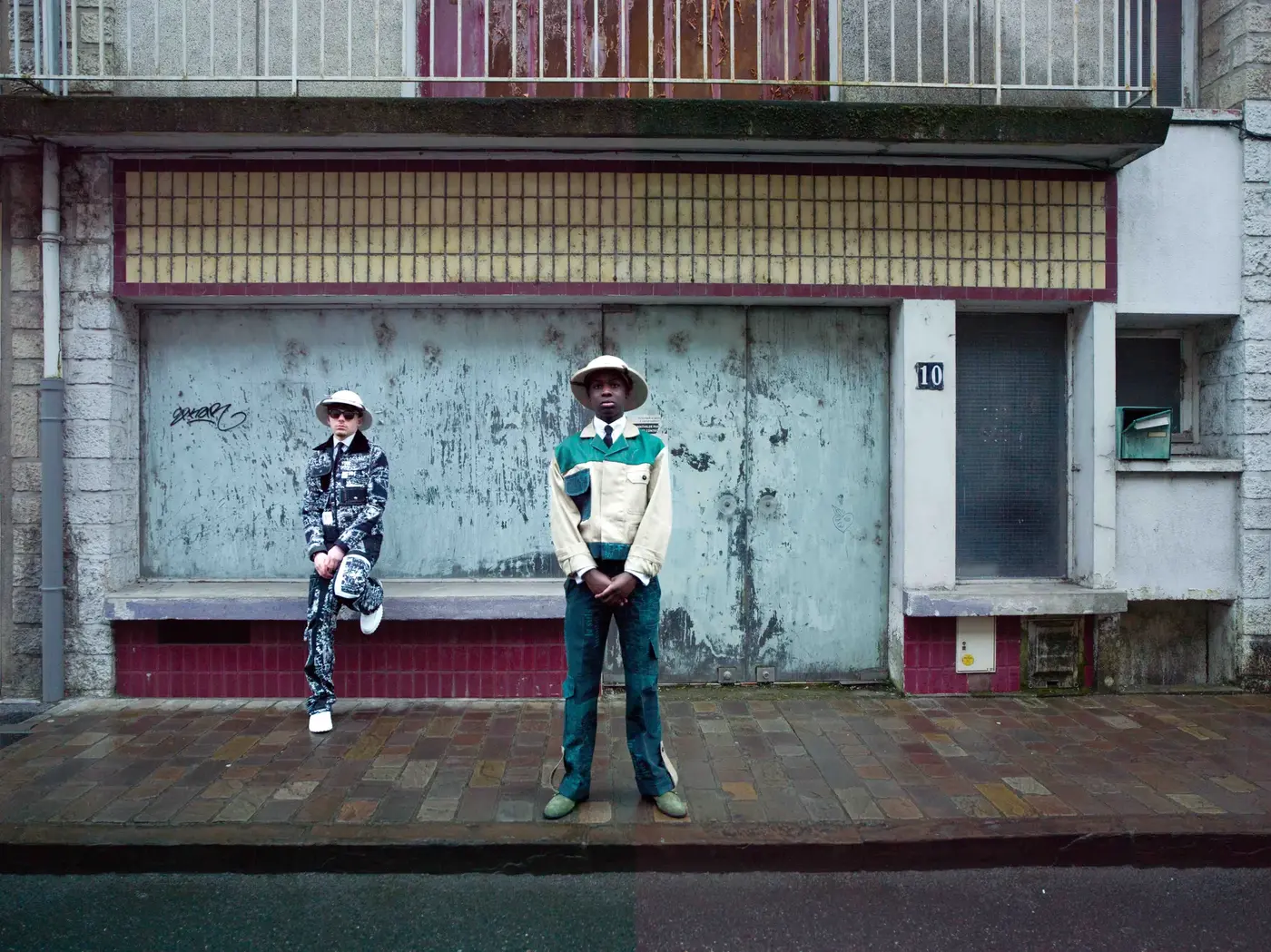 Basketteur en tenue SAPE devant une devanture de commerce, quartier de Gien