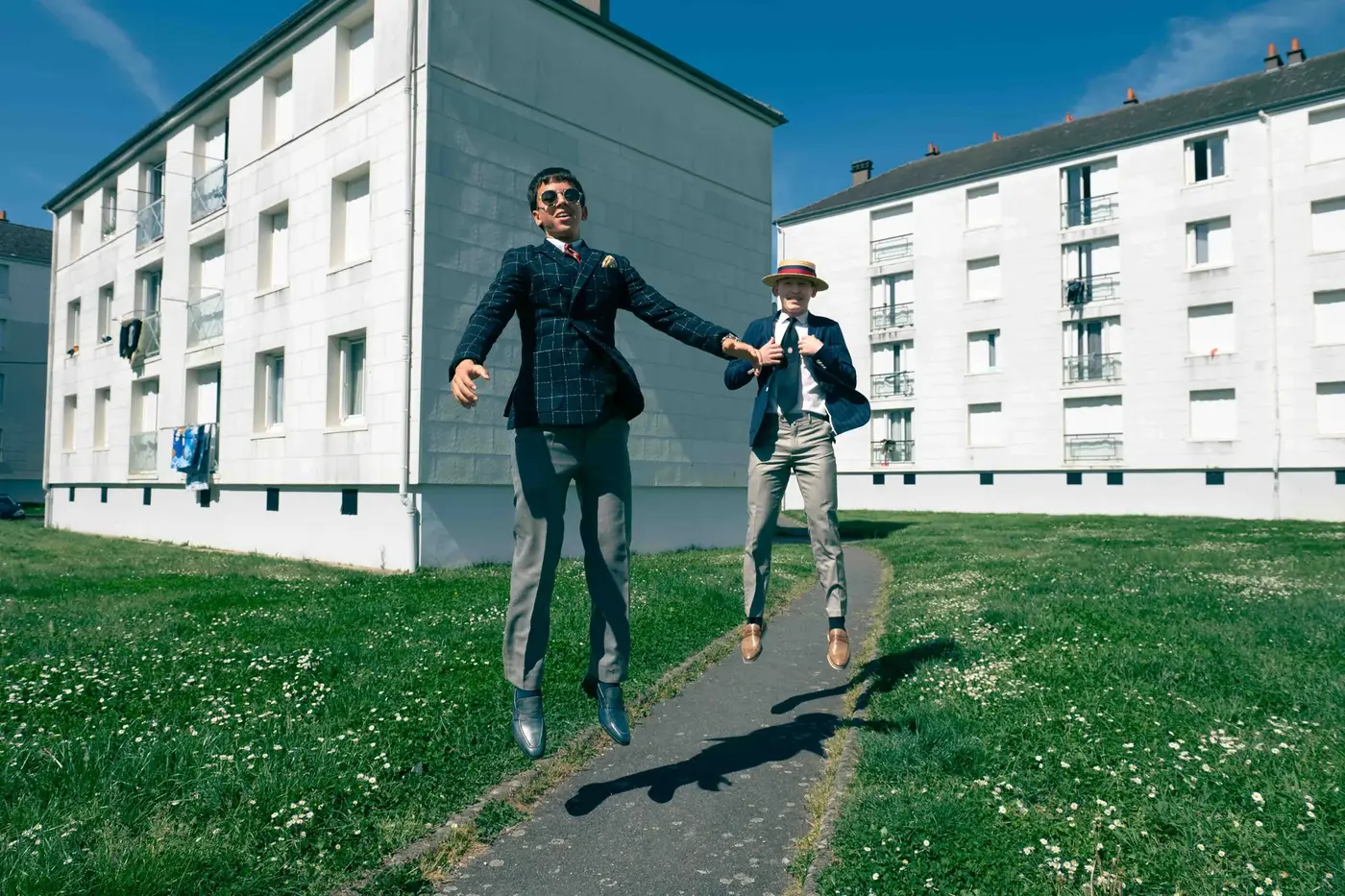 Basketteur en costume au pied d'une tour d'immeuble, ciel gris